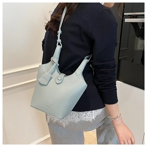 Dettaglio della borsa a secchiello in pelle azzurra con motivo litchi sulla spalla