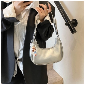 Silver crescent underarm bag with pearl charm shown in a street style fashion look