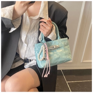 Détail du mini sac matelassé bleu clair avec fermoir argenté et breloque en perles