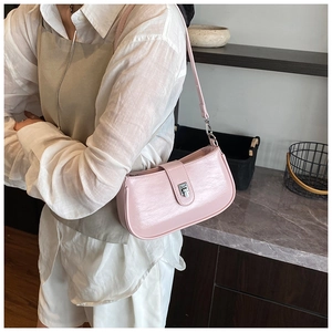 Detailed side view of a glossy light pink hobo bag with a silver metallic buckle lock