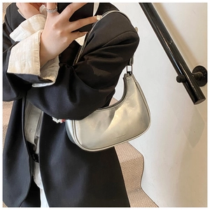 Silver metallic crescent underarm bag showing the fashion logo and zipper detail