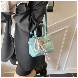 Détail du sac matelassé vert menthe avec fermoir rotatif argenté et charm perles chic