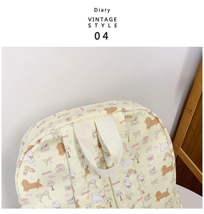 Detail of vintage cartoon print backpack with durable top handle and thick cream straps