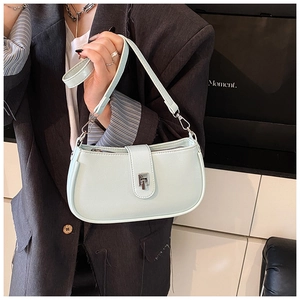 Close-up of light green PU leather underarm bag with silver twist lock on model