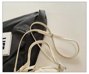 Détail de la bandoulière réglable en cuir crème avec boucle argentée élégante