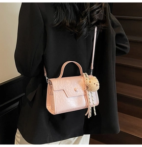 Detailed side view of a pink mini square bag with cute bear charm and silk scarf decoration