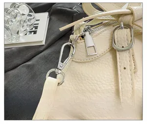 Détails de la ferronnerie argentée et du cuir grainé de ce sac à main beige élégant