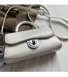 Detail view of white textured PU leather crossbody bag with silver round twist lock buckle