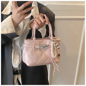 Détail du sac à main matelassé rose avec fermoir en métal et breloque en perles