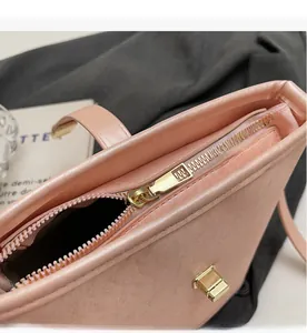Détail de la fermeture éclair dorée et du fermoir rotatif sur le sac seau en cuir rose
