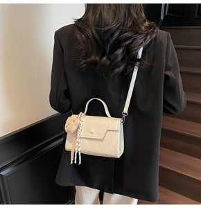 Detail of cream leather mini square bag with pearl buckle, silk scarf and bear charm