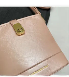 Vue détaillée du sac seau rose avec fermoir doré et texture en similicuir grainé