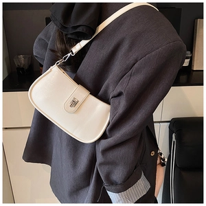 Detail of a creamy white lychee grain shoulder bag with elegant silver metal square buckle