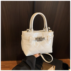 Détail du sac matelassé crème avec fermoir tournant argenté et texture cuir synthétique