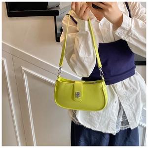 Detail of neon green textured shoulder bag featuring silver buckle and slim strap