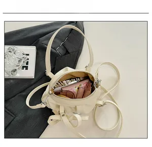 Détail de la capacité interne du sac à main plissé blanc crème avec articles essentiels