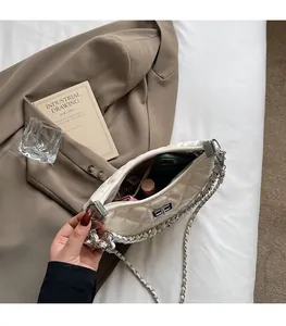 Spacious interior of beige quilted chain bag showing capacity for phone and makeup