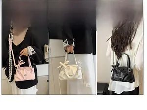 Vue détaillée des sacs à main à nœuds en rose, blanc et noir avec texture plissée
