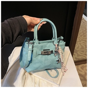Détail du petit sac matelassé bleu clair avec boucle argentée et breloque perle