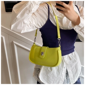 Detail view of neon yellow baguette bag with silver buckle and fine leather texture