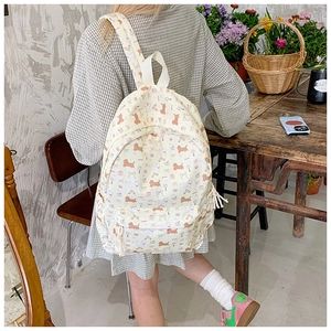 Detail of cream canvas backpack with cute puppy prints and cotton rope zippers