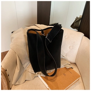 Detail einer schwarzen Beuteltasche aus Leder mit breitem Gurt und Silberschnalle