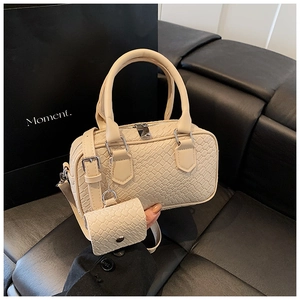 Detail of beige woven texture handbag with matching mini pouch and elegant leather handle
