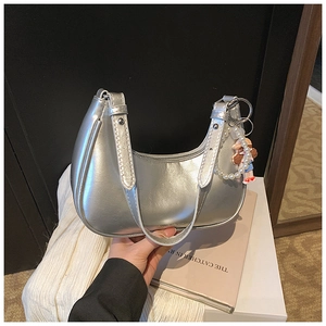 Detail view of silver metallic hobo bag with pearl cartoon charm and zipper closure