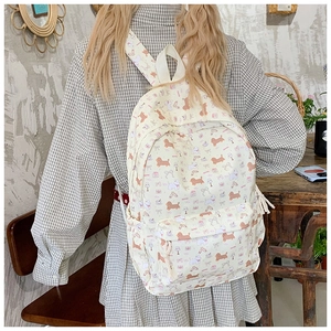 Detailed side view of beige canvas backpack with cute puppy patterns in a vintage room