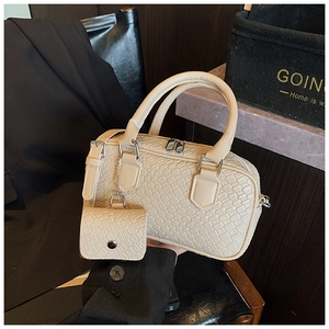Detail of cream bowling bag showing woven texture and matching coin purse attachment