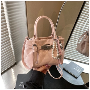 Détail du sac à main matelassé rose clair avec fermoir en métal et breloques perles
