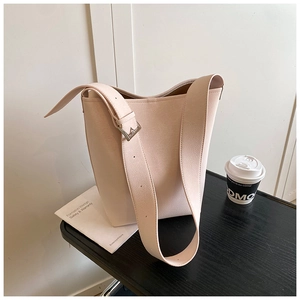 Detail der beigen Beuteltasche mit breitem Schultergurt und silberner quadratischer Schnalle