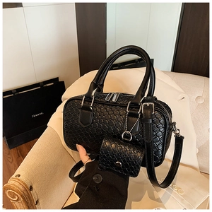 Close-up of black bowling bag with woven crocodile texture and matching mini coin purse