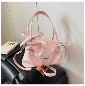 Détail du sac rose clair en cuir grainé avec nœud papillon et boucle en argent