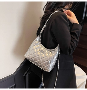 Macro shot of silver quilted hobo bag featuring metallic finish and thick chain strap
