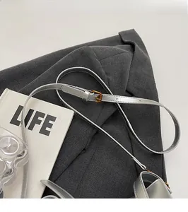 Detail of adjustable silver leather shoulder strap with a metallic buckle for women's handbag