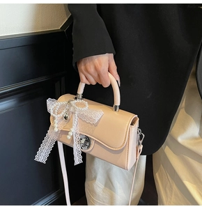 Pink crossbody bag featuring a delicate lace pearl bow and a silver heart pendant detail