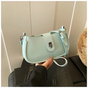Detail of mint green PU leather bag featuring a silver metal square lock and adjustable strap