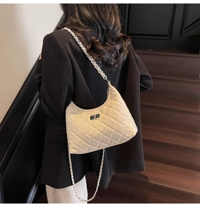 Detail of the cream quilted leather crossbody bag with silver clasp and chain strap