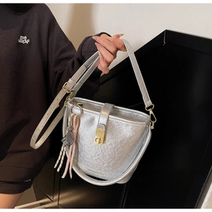 Détail du sac seau argenté avec texture métallisée et pendentif raquette de tennis