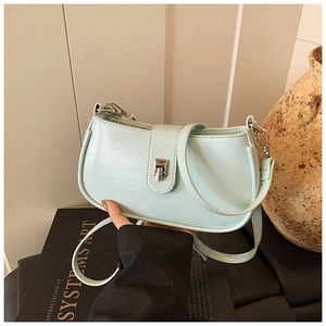 Close-up of mint green leather crossbody bucket bag with silver metal swivel lock