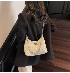 Detail of off-white quilted chain bag with silver twist lock and glossy finish