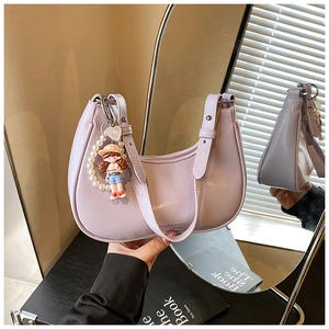 Detail view of lavender crescent bag with pearl cartoon charm and fine PU leather texture