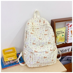 Detailed view of beige backpack with cute cartoon dog prints on a wooden surface