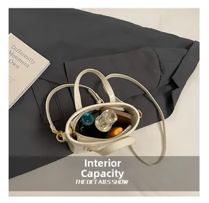 Detail of the compact internal storage capacity of the white mini bucket bag