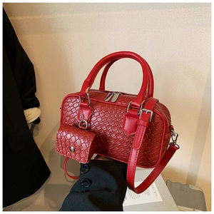 Detailed view of red woven texture on a bowling handbag with mini bag charm accessory