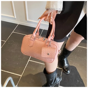 Detail of pink woven bowling bag featuring texture and mini coin purse attachment