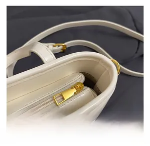 Close-up of white bucket bag featuring a premium gold metal zipper and hardware details