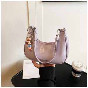 Detail of lavender crescent shoulder bag with pearl decor and a cartoon pendant charm