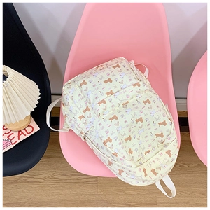 Detail of cute bear pattern and durable woven straps on the cream school backpack